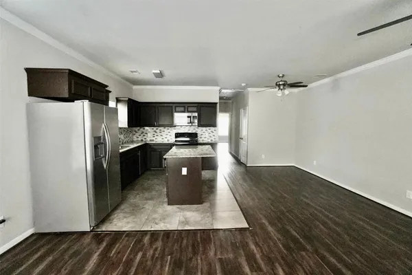 a kitchen with granite countertop a refrigerator and a stove top oven