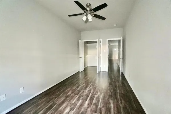 a view of a room with wooden floor and a ceiling fan