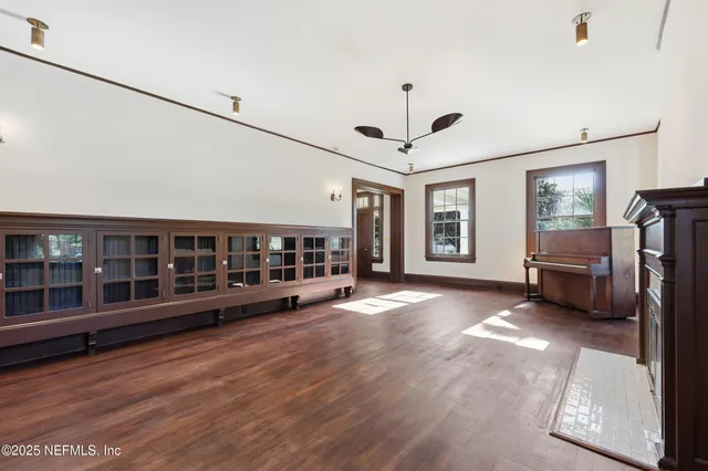 a view of a hallway with wooden floor and a living room