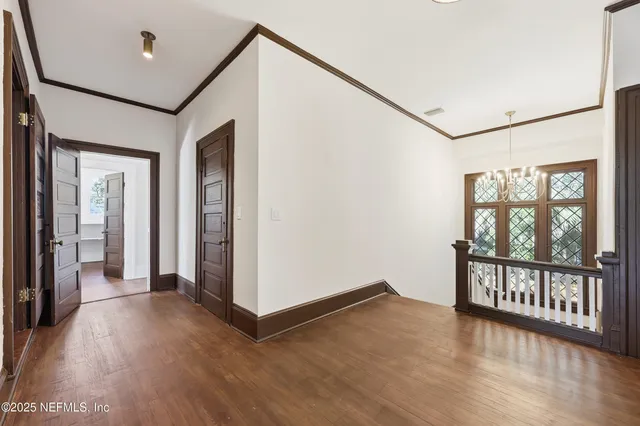 a view of a hallway with wooden floor and a window