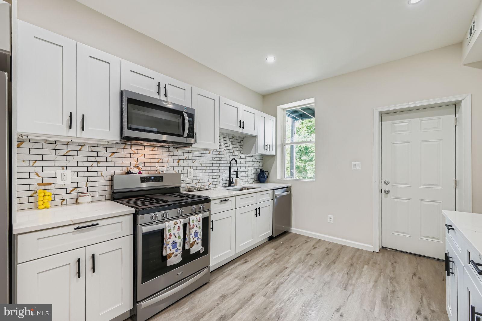 3429 Reisterstown Road Baltimore, MD 21215 - Photo 13 of 28 a kitchen with a stove a sink and a microwave