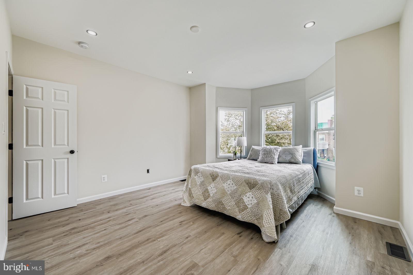 3429 Reisterstown Road Baltimore, MD 21215 - Photo 21 of 28 a bedroom with a large bed and wooden floor