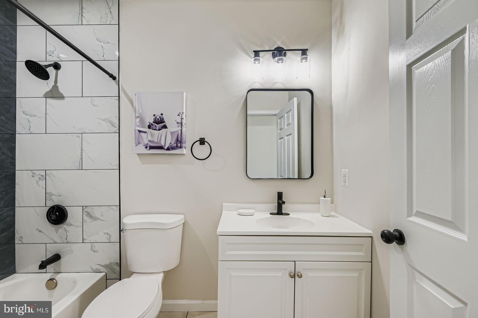 3429 Reisterstown Road Baltimore, MD 21215 - Photo 25 of 28 a bathroom with a toilet sink vanity and mirror