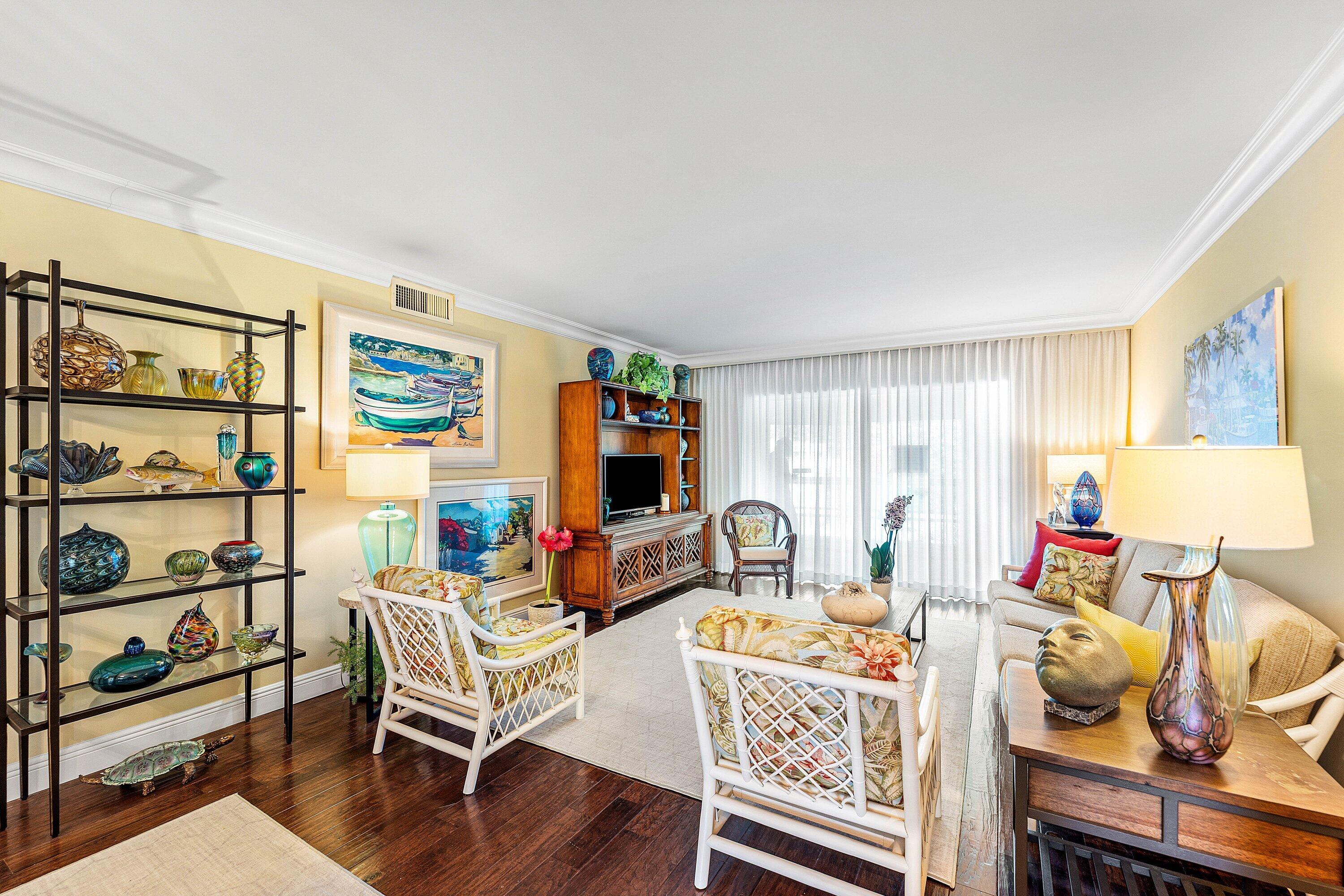 800 East Camino Real, Unit 409 Boca Raton, FL 33432 - Photo 13 of 37 a living room with furniture a flat screen tv and a table