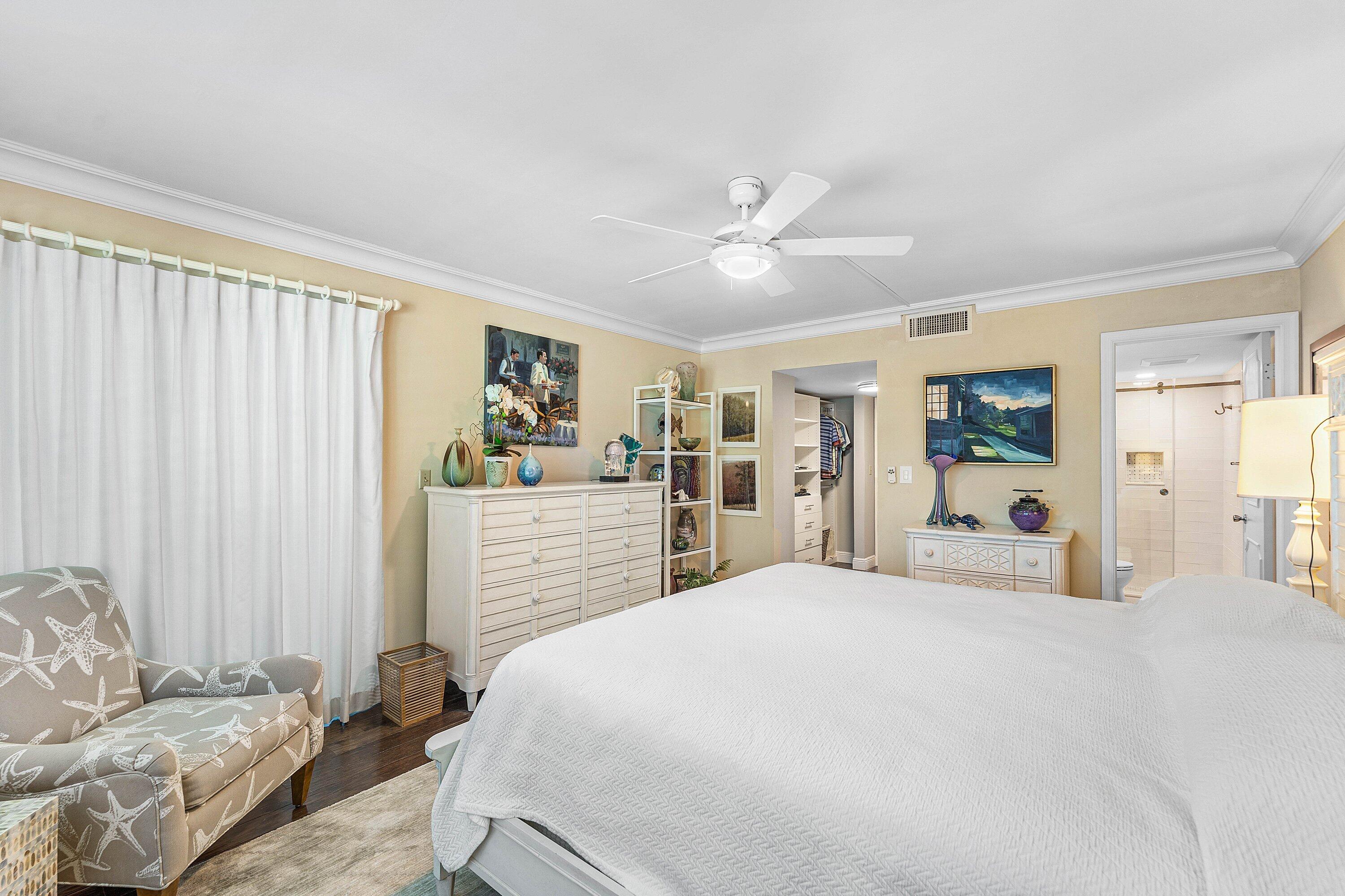 800 East Camino Real, Unit 409 Boca Raton, FL 33432 - Photo 21 of 37 a bedroom with a large bed and a chandelier