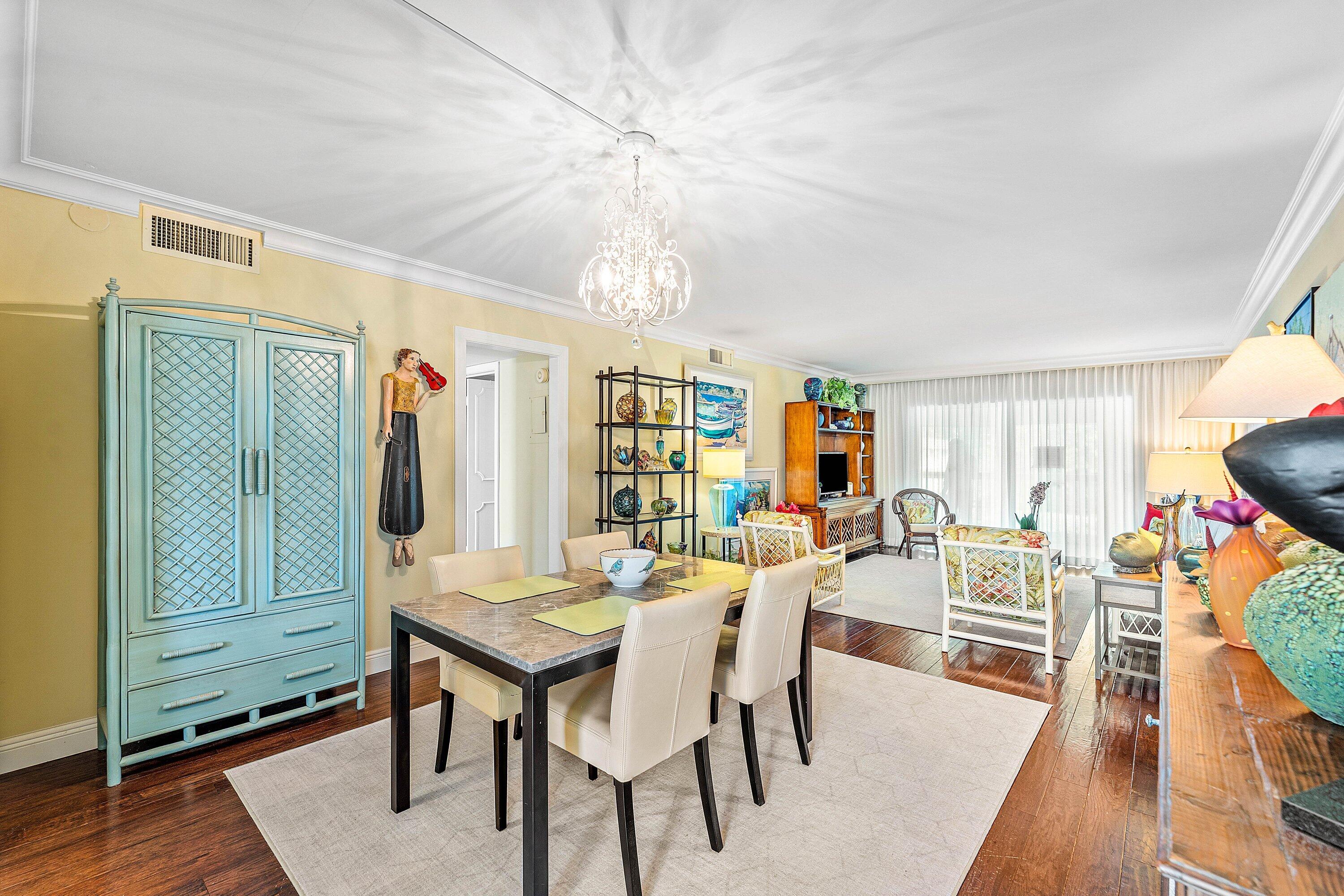 800 East Camino Real, Unit 409 Boca Raton, FL 33432 - Photo 7 of 37 a view of a dining room with furniture and wooden floor