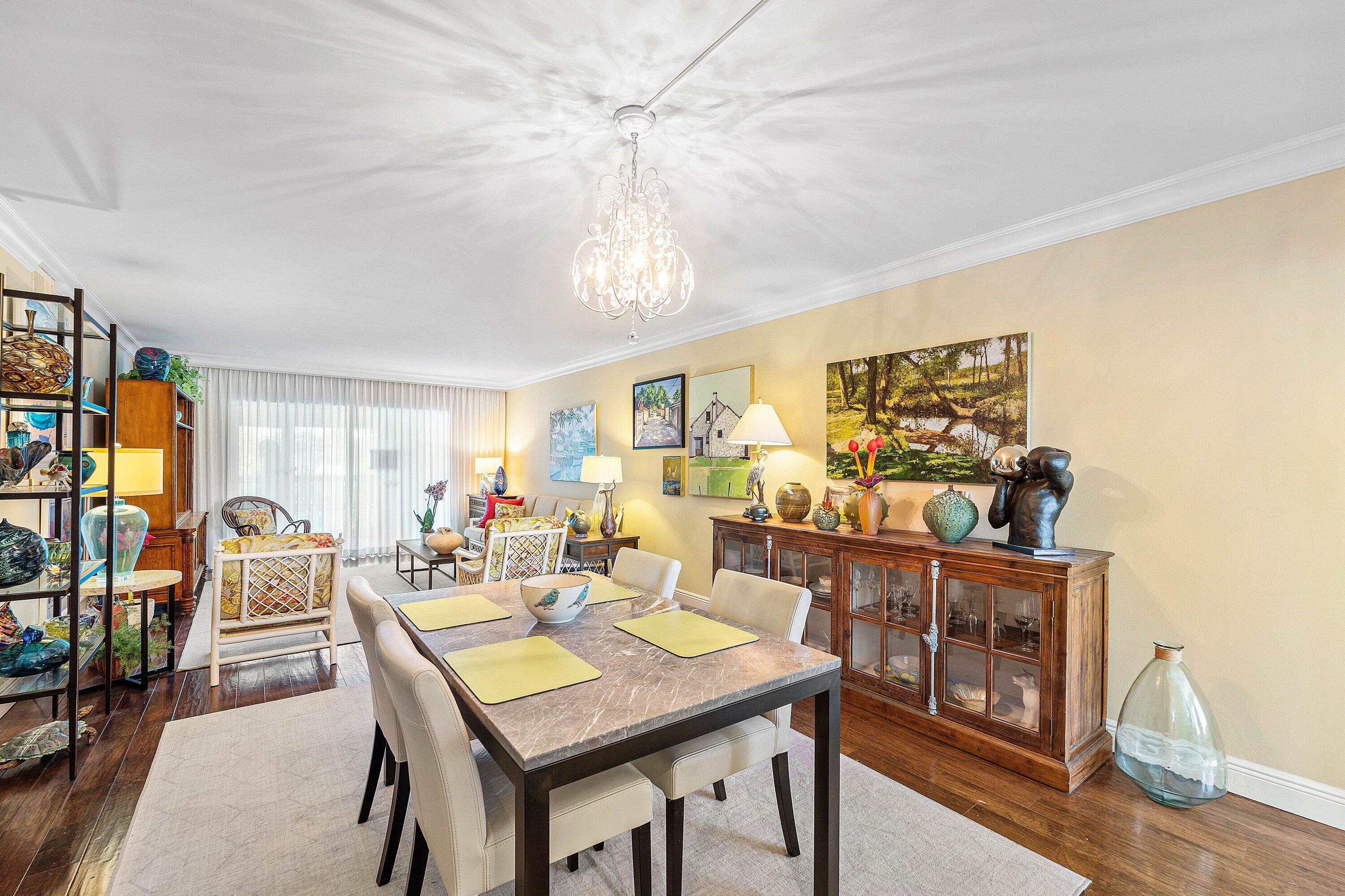 800 East Camino Real, Unit 409 Boca Raton, FL 33432 - Photo 10 of 37 a view of a dining room with furniture window and wooden floor