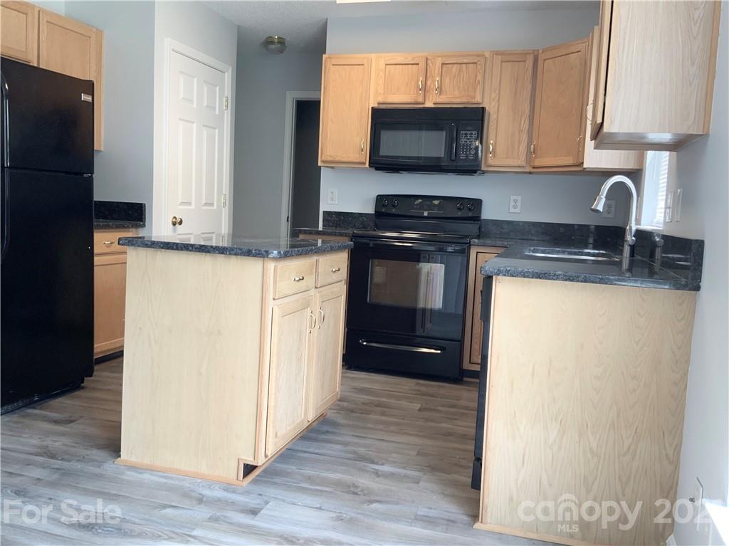 5136 Deerton Road Charlotte, NC 28269 - Photo 4 of 18 a kitchen with stainless steel appliances a refrigerator stove and microwave