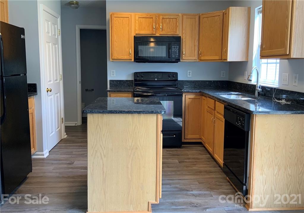 5136 Deerton Road Charlotte, NC 28269 - Photo 5 of 18 a kitchen with a refrigerator and a stove top oven