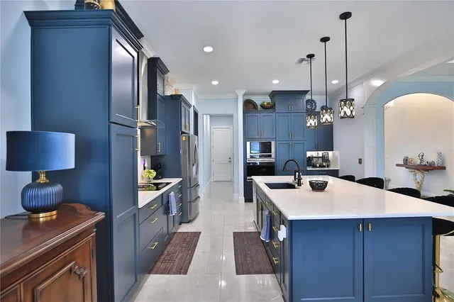 a kitchen with kitchen island a sink stove and refrigerator