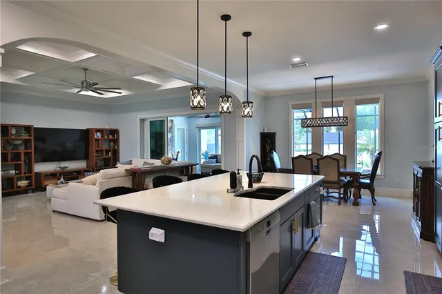 a view of a dining room and livingroom with furniture wooden floor a chandelier