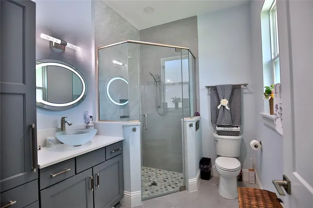a bathroom with a sink vanity mirror and toilet