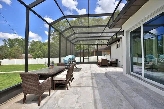 a view of a patio with a table chairs and a backyard