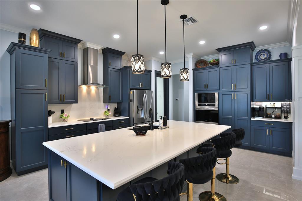 5845 Southwest 43rd St Road Ocala, FL 34474 - Photo 10 of 38 a kitchen with stainless steel appliances kitchen island a table chairs and refrigerator