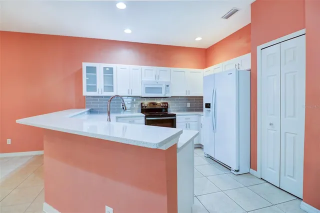 a kitchen with granite countertop a stove and a refrigerator