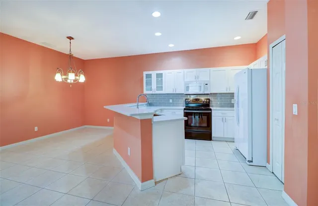 a kitchen with a sink and chandelier