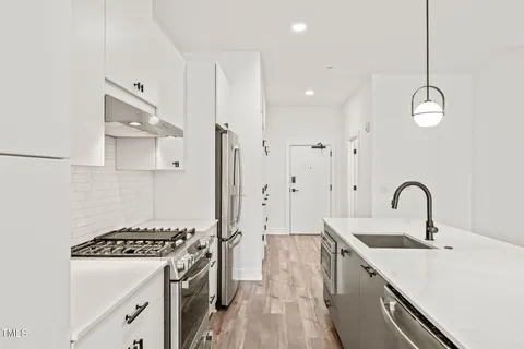 a large white kitchen with stainless steel appliances