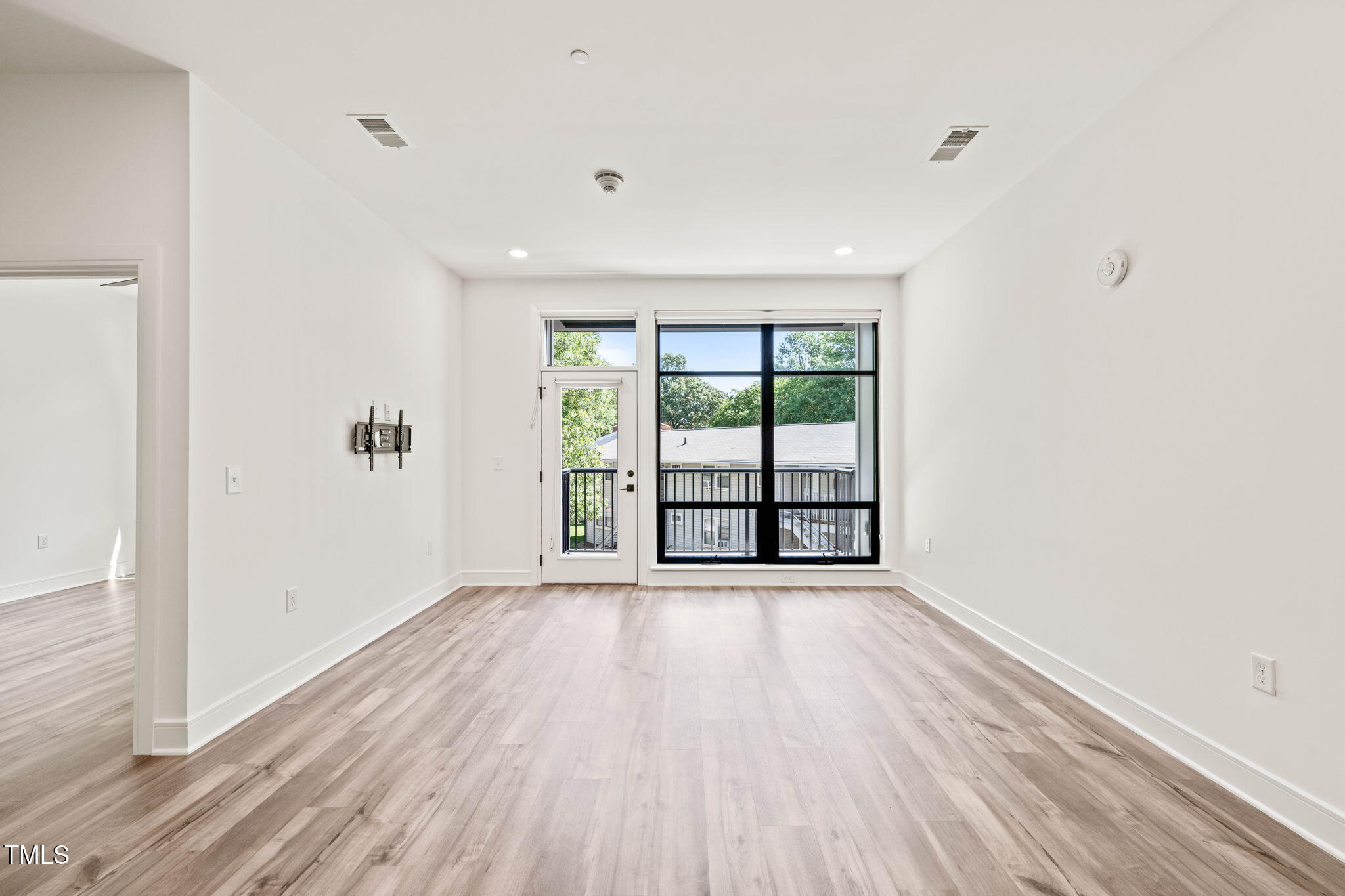 615 Daniels Street, Unit 215 Raleigh, NC 27605 - Photo 11 of 37 wooden floor in an empty room with a window