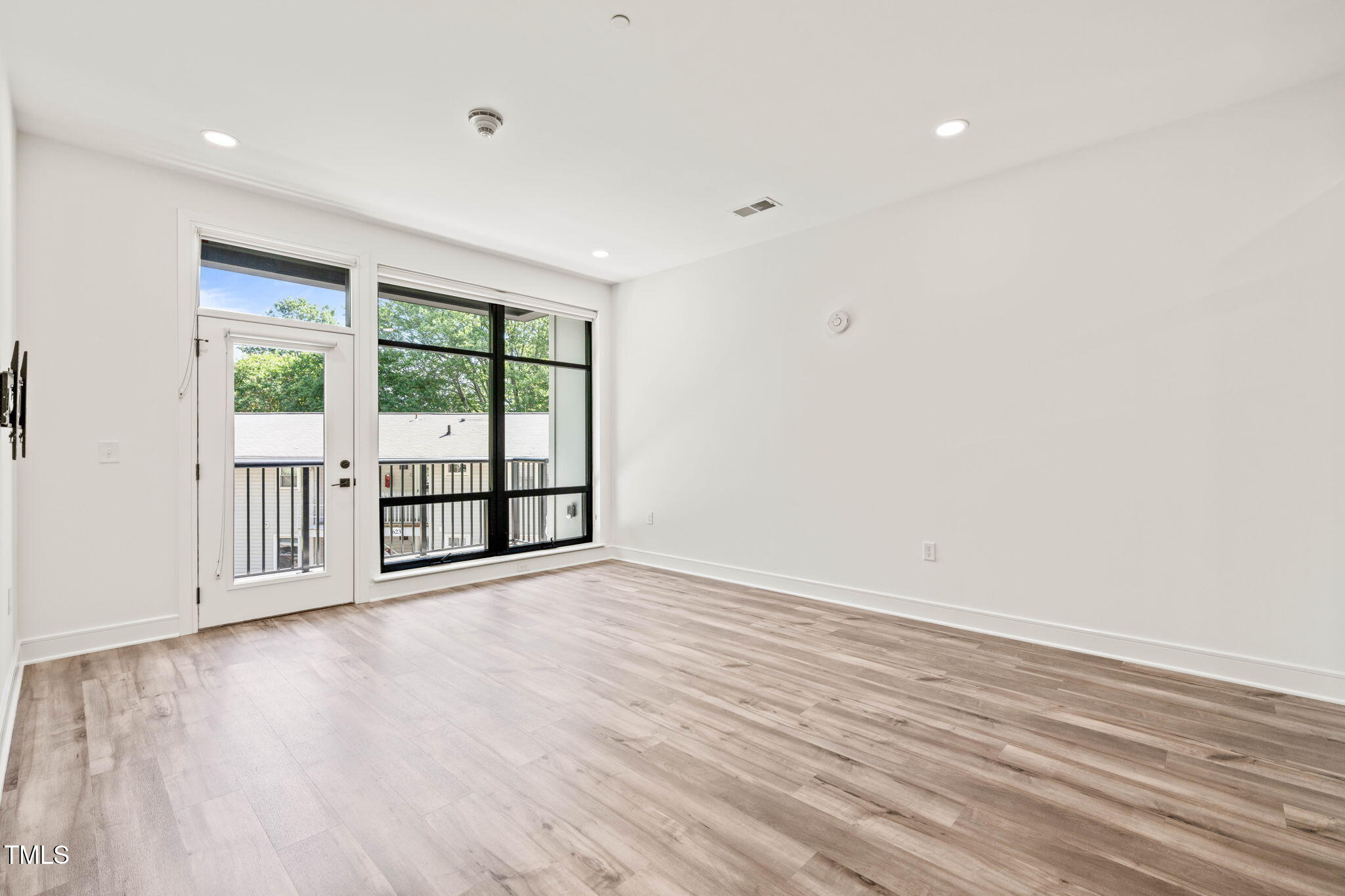 615 Daniels Street, Unit 215 Raleigh, NC 27605 - Photo 14 of 37 wooden floor in an empty room with a window