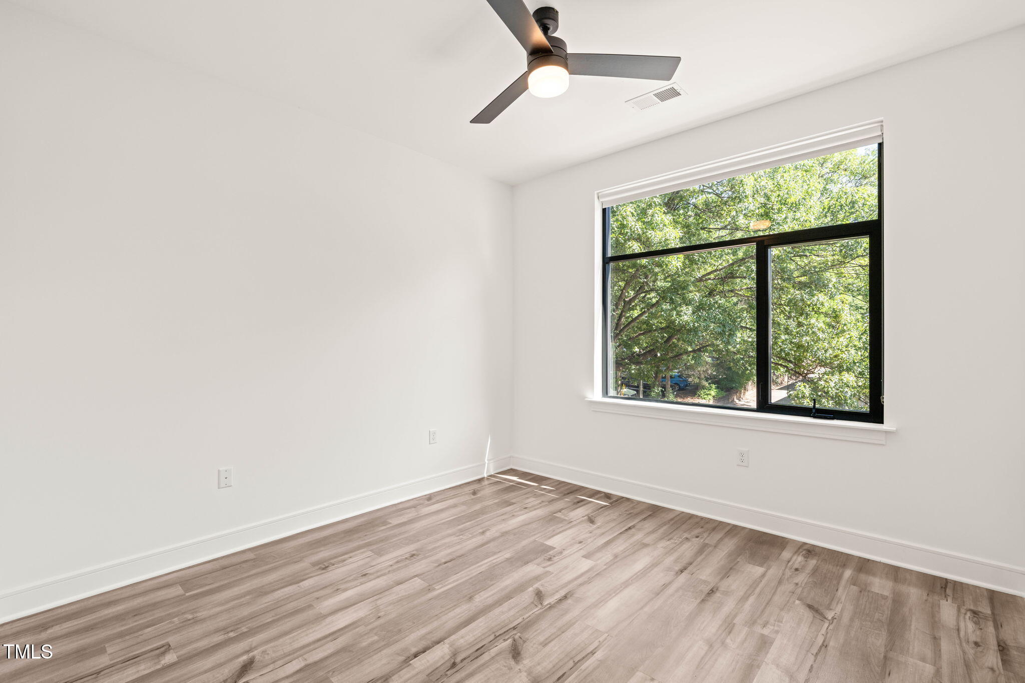 615 Daniels Street, Unit 215 Raleigh, NC 27605 - Photo 16 of 37 an empty room with wooden floor fan and windows