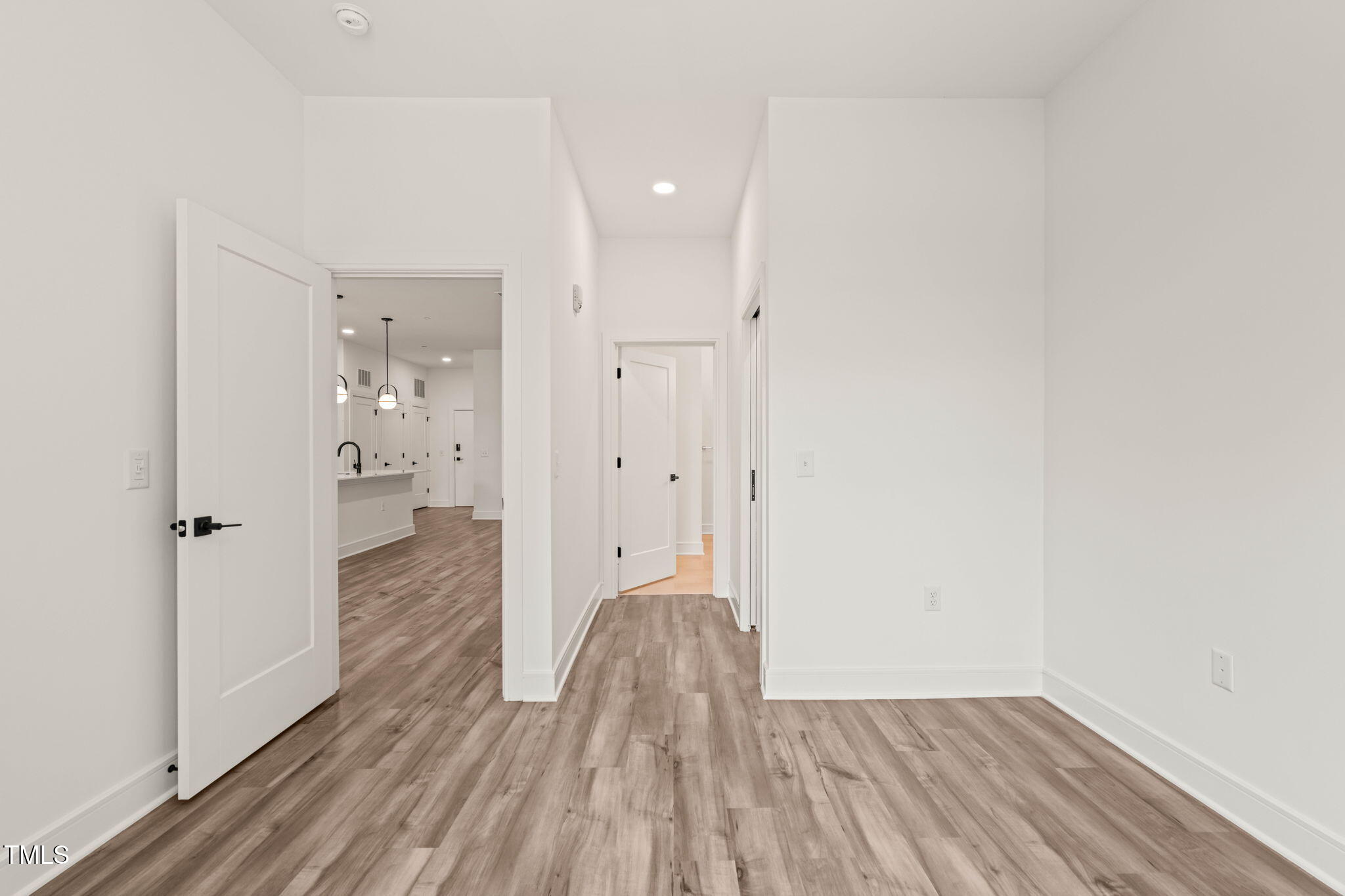 615 Daniels Street, Unit 215 Raleigh, NC 27605 - Photo 17 of 37 a view of a hallway with wooden floor and a bathroom