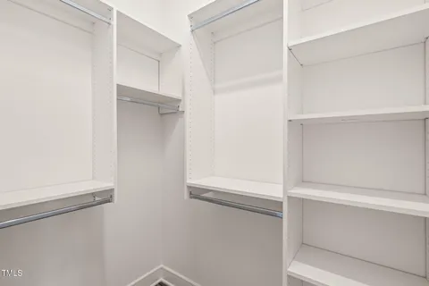 a view of a hallway with wooden floor and a bathroom