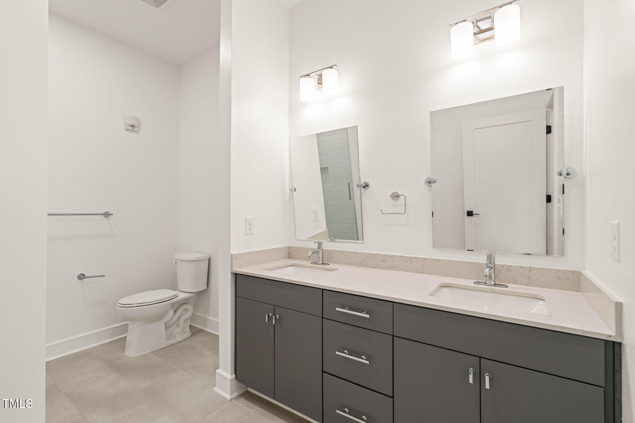 615 Daniels Street, Unit 215 Raleigh, NC 27605 - Photo 19 of 37 a bathroom with a double vanity sink toilet and mirror