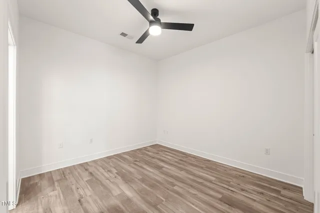 a view of empty room with wooden floor