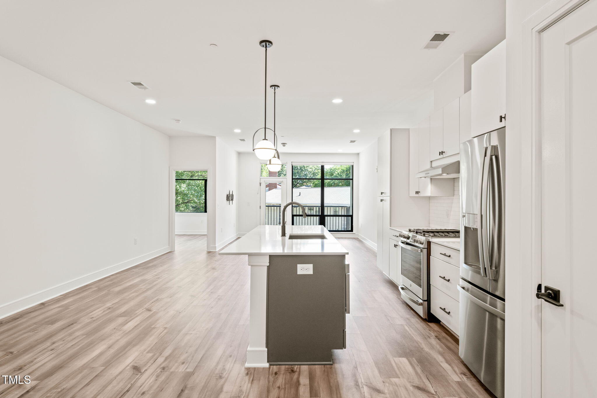 615 Daniels Street, Unit 215 Raleigh, NC 27605 - Photo 7 of 37 a kitchen with stainless steel appliances granite countertop a refrigerator a sink dishwasher a stove and white countertops with wooden floor