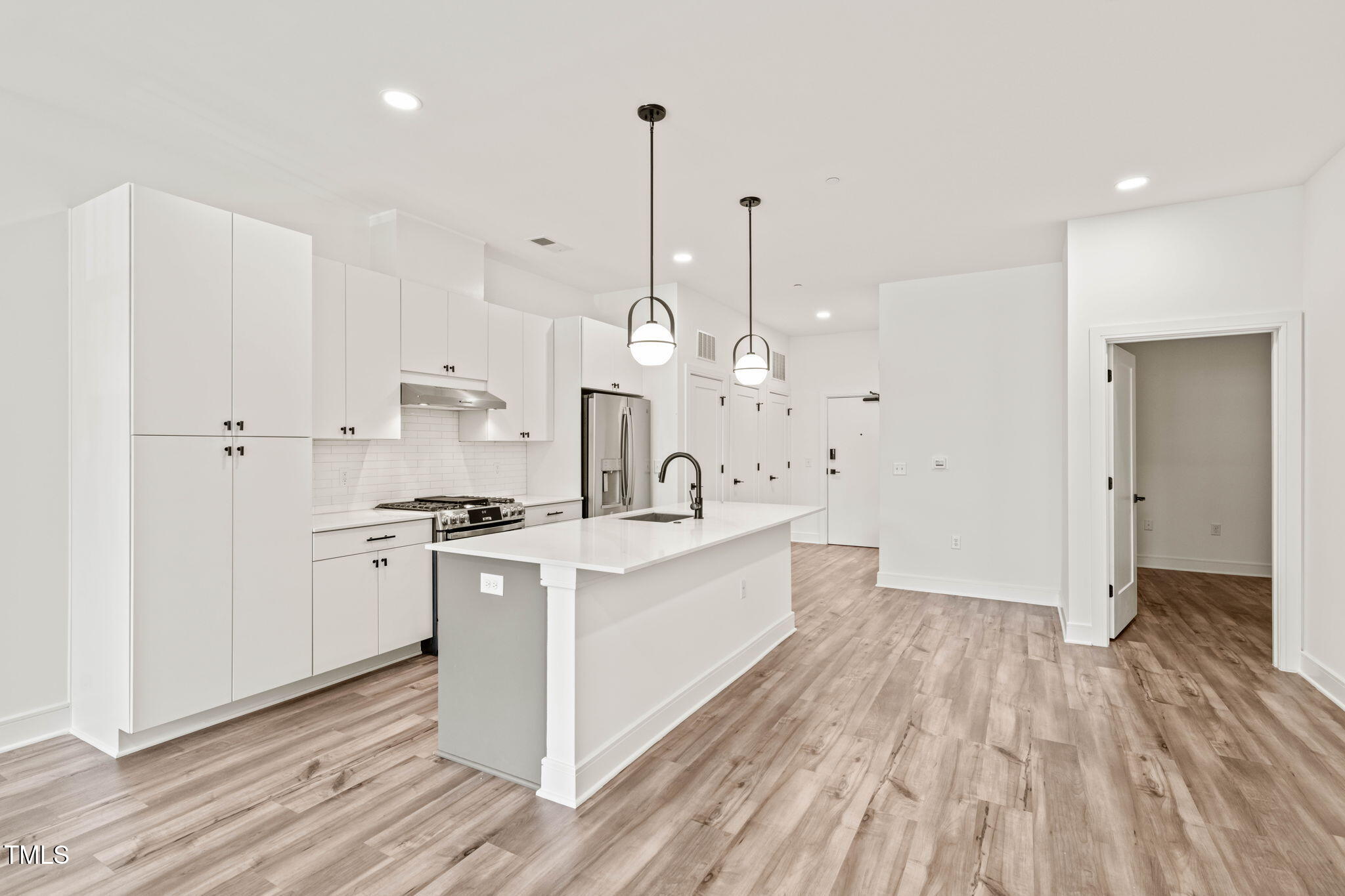 615 Daniels Street, Unit 215 Raleigh, NC 27605 - Photo 9 of 37 a large white kitchen with stainless steel appliances