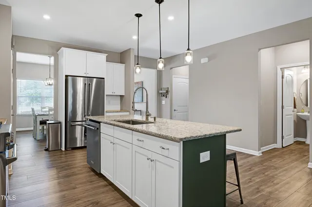 a kitchen with refrigerator a sink and wooden floor