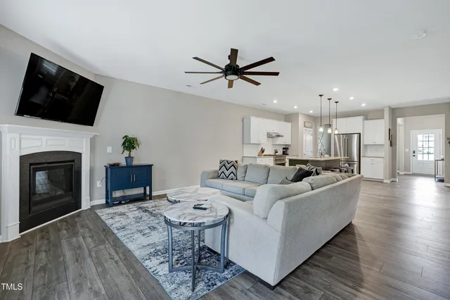 a living room with furniture a fireplace and a flat screen tv