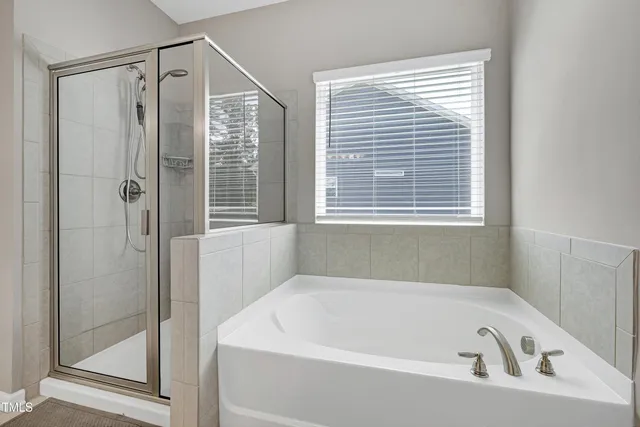 a white bath tub sitting next to a shower
