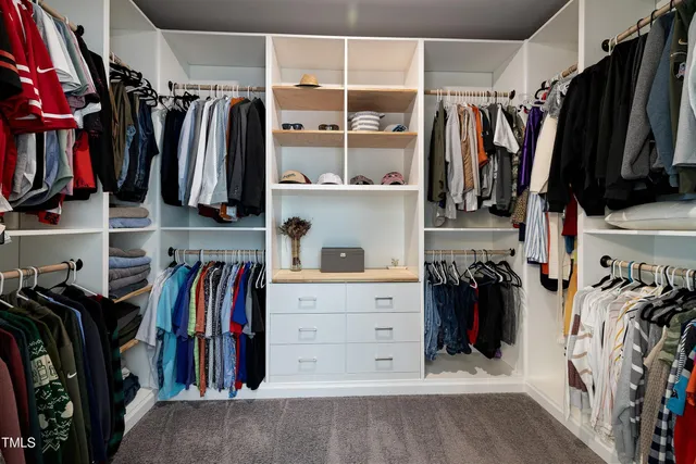 a view of walk in closet with clothes and shoes