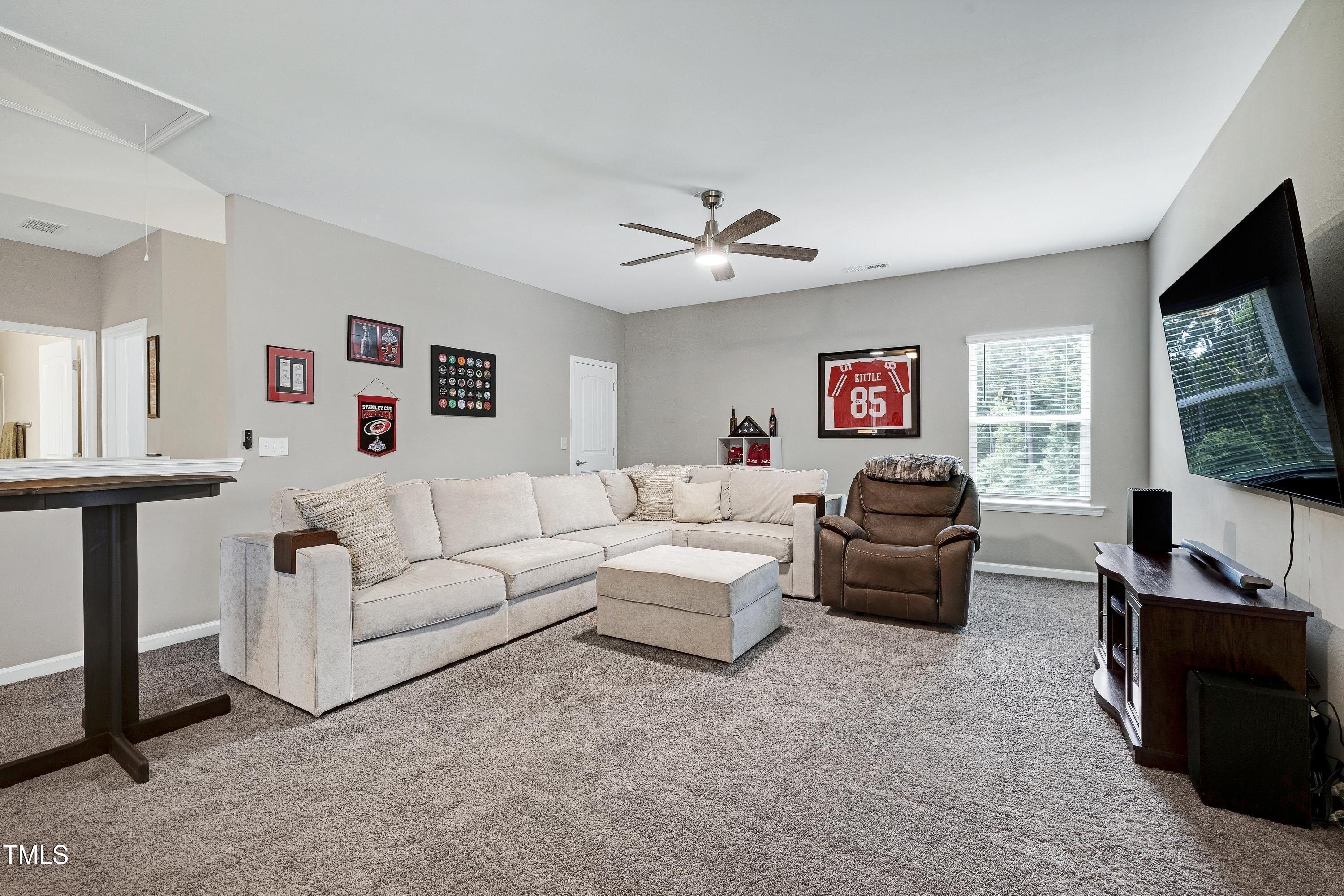 5300 Trilogy Farm Drive Raleigh, NC 27603 - Photo 29 of 50 a living room with furniture a flat screen tv and a window