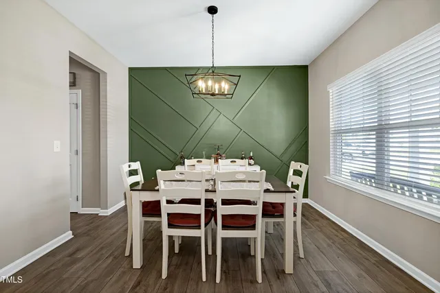 a dining room with furniture a chandelier and wooden floor