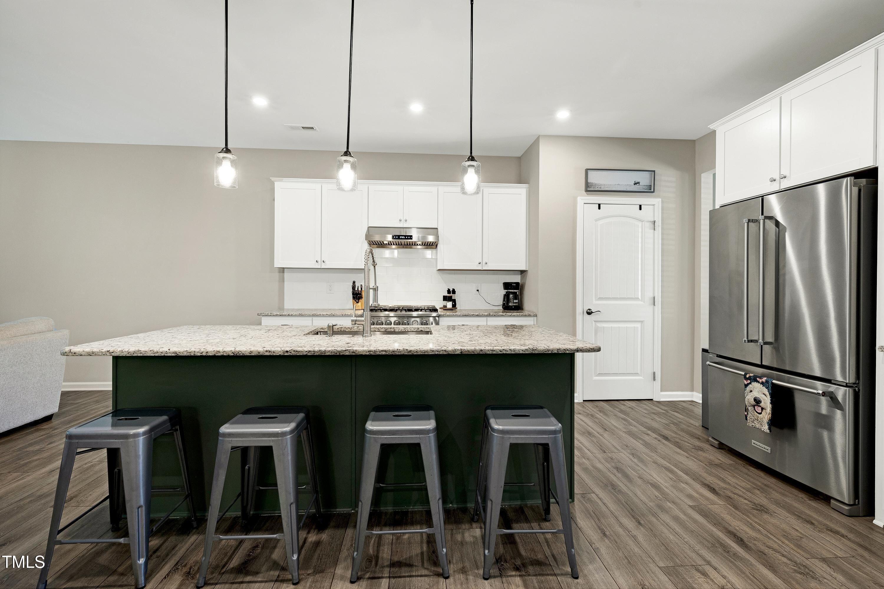 5300 Trilogy Farm Drive Raleigh, NC 27603 - Photo 9 of 50 a kitchen with granite countertop a table chairs stainless steel appliances and cabinets