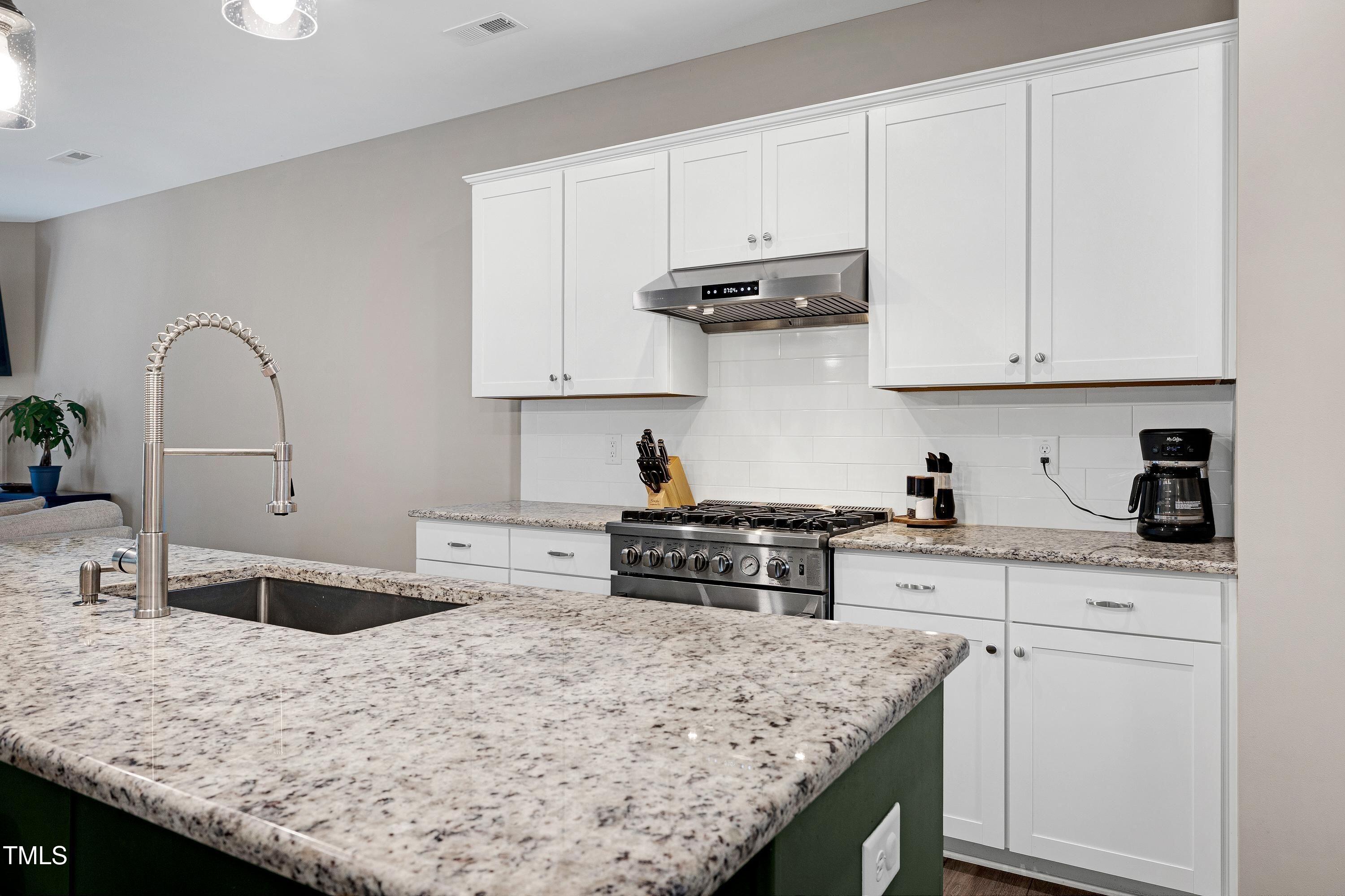 5300 Trilogy Farm Drive Raleigh, NC 27603 - Photo 10 of 50 a kitchen with granite countertop a sink a stove and cabinets