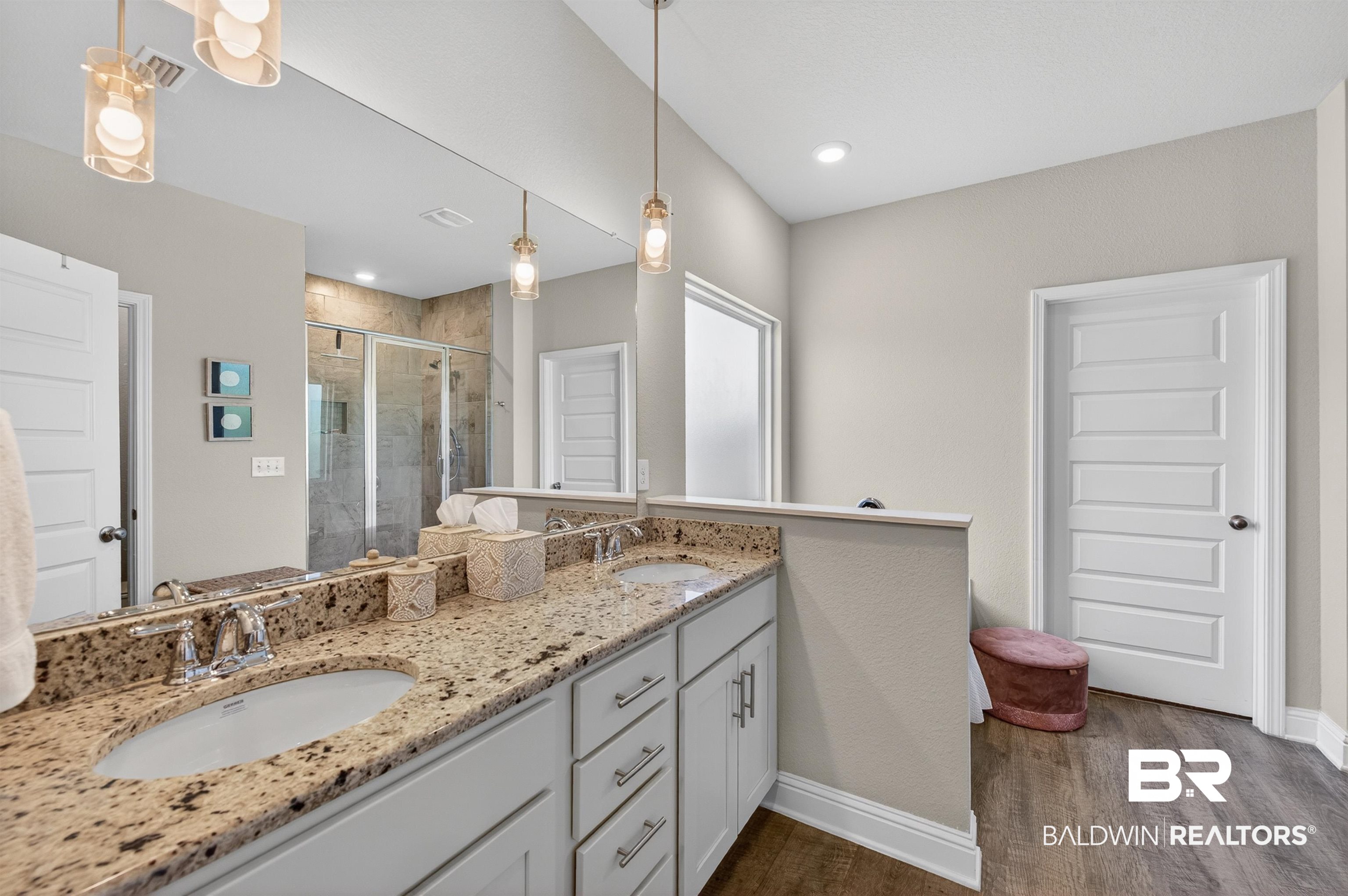 8735 Bronze Lane Foley, AL 36535 - Photo 24 of 58 Spacious bathroom featuring a dual vanity with granite-finish countertops, white cabinetry, and two undermount sinks