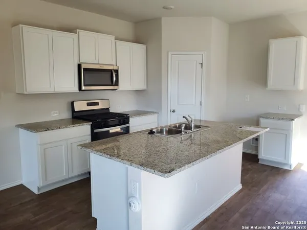 a kitchen with stainless steel appliances granite countertop a sink stove and microwave