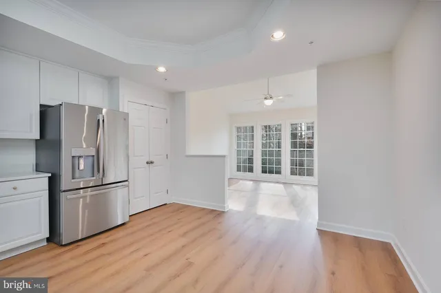 a view of a kitchen with wooden floor electronic appliances and windows