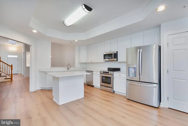 a kitchen with white cabinets and stainless steel appliances