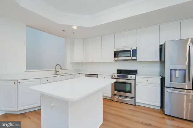 a kitchen with a sink a stove a refrigerator and cabinets