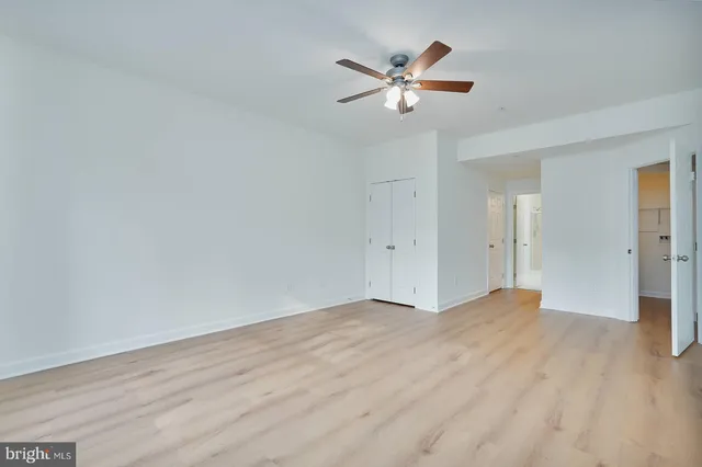 a view of an empty room and chandelier fan