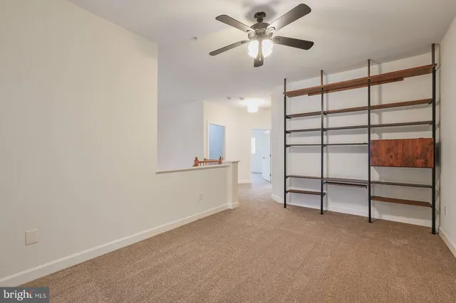 a view of an empty room with a ceiling fan