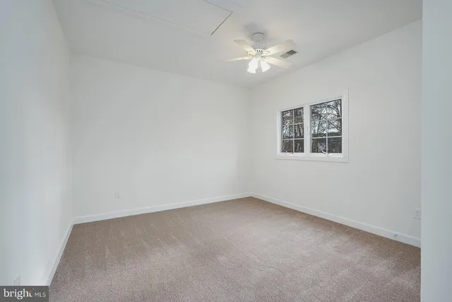 an empty room with a chandelier fan