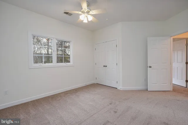 a view of empty room with chandelier fan