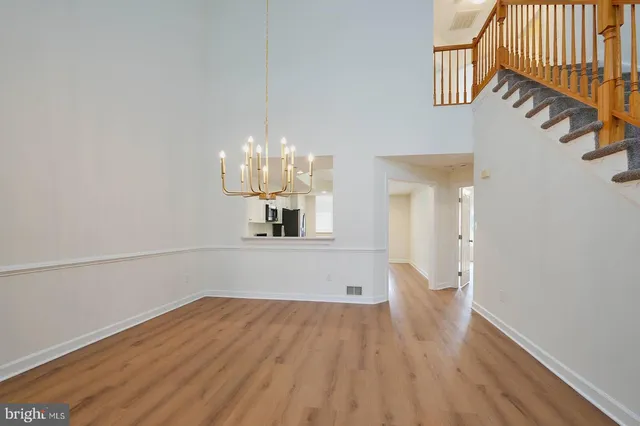 a view of a room with wooden floor and chandelier