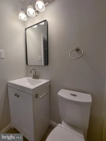 a bathroom with a toilet a sink and mirror