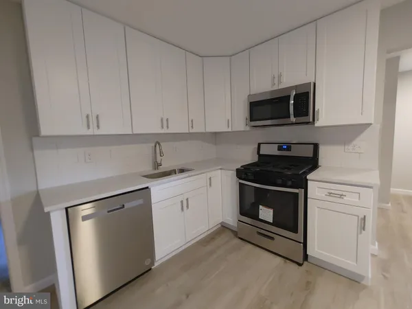 a kitchen with white cabinets and stainless steel appliances